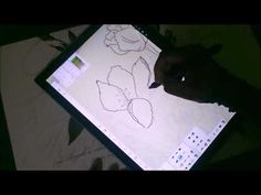 someone is drawing flowers on a tablet screen