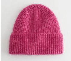 a pink knitted beanie on a white background