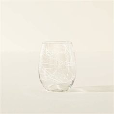 a clear wine glass sitting on top of a white tableclothed surface with lines drawn across it