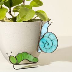 a potted plant with a blue and green butterfly decoration on it's side