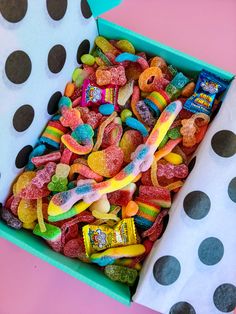 a box filled with gummy bears and other candies next to a polka dot wall