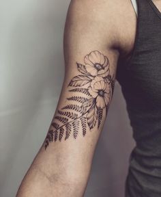 a woman's arm with a flower tattoo on the left side of her arm