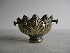 an ornate metal bowl with two handles