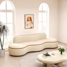 a living room filled with white furniture and large arched windows, along with potted plants