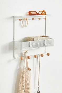 a pair of glasses hanging on a white wall next to a shelf with two pairs of eyeglasses