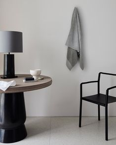 a chair and table with a towel hanging on the wall