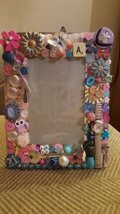 a photo frame decorated with buttons and flowers