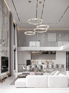 a modern living room with white furniture and chandelier hanging from the ceiling above