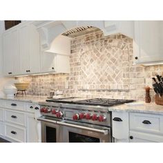 a stove top oven sitting inside of a kitchen next to white cabinets and counter tops