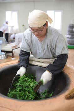 a man in a white turban is cutting up some greens