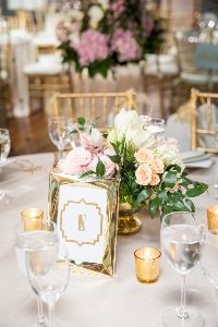 a vase filled with lots of flowers on top of a white table covered in candles