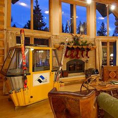 a living room filled with lots of furniture next to a fire place in a log cabin