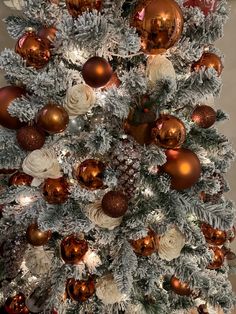 a white christmas tree with gold and silver ornaments