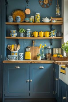 a kitchen with blue cabinets and yellow accessories on the countertop, along with wooden shelves