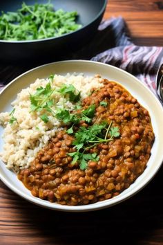 a white plate topped with beans and rice next to a skillet filled with greens