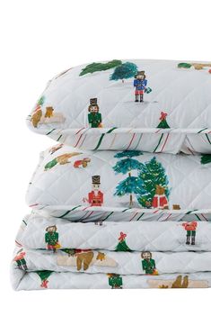 three white quilted bedspreads with christmas decorations and bears on them, stacked next to each other