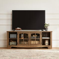 a flat screen tv sitting on top of a wooden entertainment center in a living room