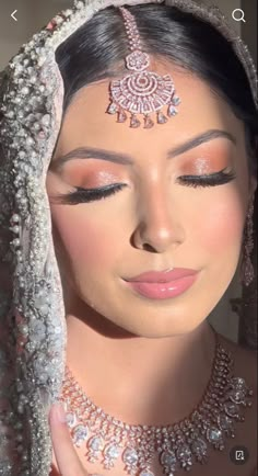 a woman wearing a bridal veil and jewelry