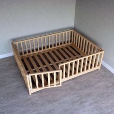 a wooden bed frame sitting on top of a hard wood floor next to a wall