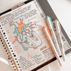 two pens are sitting on top of a notebook with an illustration of a heart and the inside of it