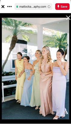 two women in dresses standing next to each other and one is holding her hand up