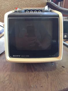 an old television sitting on top of a wooden table