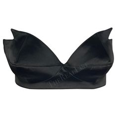 Presenting a stunning black satin Thierry Mugler pointed bralette, designed by Manfred Mugler. From the 1980s, this bralette is constructed entirely of shiny black satin. The bralette features a sweetheart cut and is made complete with pointed accents on either cut, giving this bralette an undeniable Mugler touch. A must-have for any Thierry Mugler lover, this bralette can be sported on its own or layered with your favorite blazer. Approximate measurements: Size - 42FR Top of bust to hem: 5" Bus Black Crop Top With Built-in Bra For Evening, Elegant Low-cut Crop Top For Party, Chic Evening Bra With Triangle Top, Elegant Party Bra With Triangle Top, Party Satin Crop Top With Built-in Bra, Elegant Evening Crop Top With Built-in Bra, Elegant Satin Crop Top For Party, Summer Party Satin Bra, Fitted Satin Bra With Removable Pads