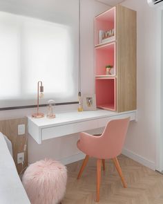 a pink chair sits in front of a white desk and shelving unit with shelves