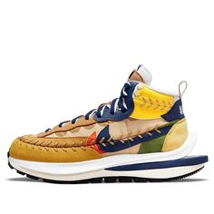 Nike and sacai have teamed up with French fashion label Jean Paul Gaultier to release the Vaporwaffle Sacai x Jean Paul Gaultier. This updated version of the popular Vaporwaffle features a mid-cut collar and prominent baseball-style stitching. The khaki textile upper is overlaid with suede paneling in beige, green and yellow, and accented with double-layered leather Swooshes in blue and orange. Dual Nike and sacai branding lands on the heel tab and doubled-up tongue tags, while ‘Jean Pa’ appears on the lateral side of the shoe in white embroidery, designed with dual branding and a comfortable double-stacked foam midsole. It also features split heel construction and Nike’s classic waffle tread underfoot, making it perfect for athletes or everyday use. (SNKR/Casual/Unisex) Nike X Sacai, Nike Sacai, Marathon Running Shoes, Marathon Running, Blue And Orange, Running Shoes Sneakers, White Embroidery, Green And Yellow, Paul Gaultier