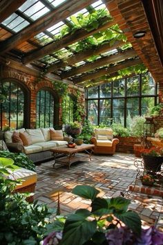 an outdoor living room with lots of plants and flowers on the walls, along with large windows