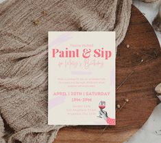 an image of paint and sip birthday party card on wood table with flowers in the background