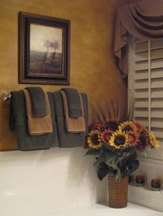 a bathroom with sunflowers and towels hanging on the wall