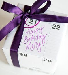 a birthday present wrapped in purple ribbon