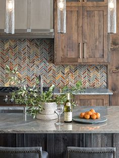 a kitchen with wooden cabinets, marble counter tops and an island topped with fruit on it