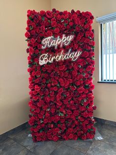 a large red flower wall with the words happy birthday written on it in white letters