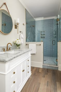 a bathroom with two sinks, a shower and a large mirror on the wall above it