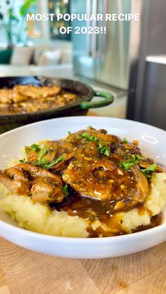 a white plate topped with mashed potatoes covered in gravy