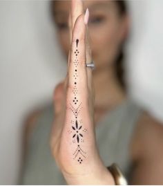 a woman is holding her hand up in the air with an intricate design on it