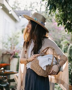 a woman wearing a hat and holding a basket