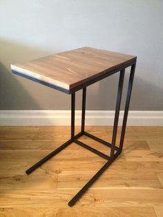 a wooden table sitting on top of a hard wood floor next to a white wall