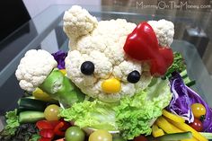 a stuffed animal made out of vegetables and fruits is sitting on top of a glass table