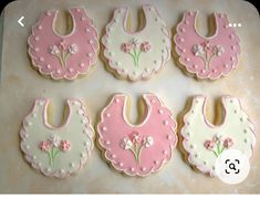 decorated cookies in the shape of bibs and bibs with flowers on them are ready to be eaten