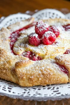 raspberry pie with powdered sugar on top sitting on a white doily