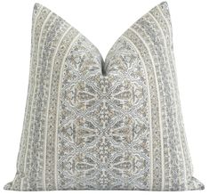 a blue and white pillow with an intricate design on the front, sitting on a white background