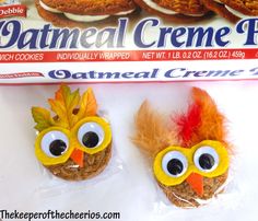 two cookies with googly eyes and fake leaves on them next to a box of oatmeal creme pies