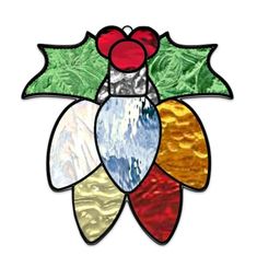 a stained glass christmas ornament with holly leaves and berries on it's side