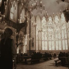 a man standing in front of a large church filled with people and chandeliers