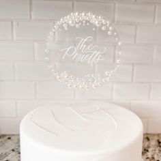 a white cake topped with a frosted topper and the words, the prettie