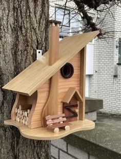 a wooden bird house on the side of a tree