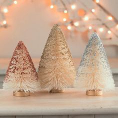 three small christmas trees sitting on top of a table